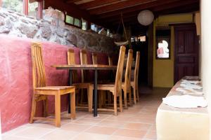 AlajeróEl Drago Rural House的粉红色墙壁的房间里一张桌子和椅子