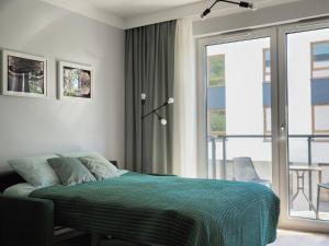 弗罗茨瓦夫Kropla Rosy的一间带绿色床的卧室和一个阳台