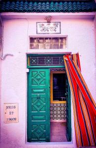 马赫迪耶Dar EL Hamra Maison Typique的建筑上方有标志的绿色门