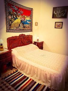 马赫迪耶Dar EL Hamra Maison Typique的卧室配有一张床,墙上挂有绘画作品