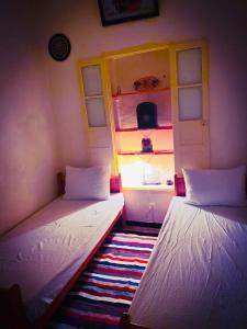 马赫迪耶Dar EL Hamra Maison Typique的带窗户的客房内设有两张单人床。