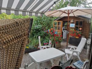 OesterdeichstrichÖsterdeichstrich的庭院配有桌椅和遮阳伞。