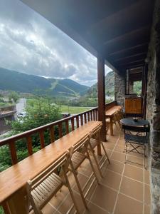 索尔德乌Vall del Riu - Llar dolça llar的阳台设有长凳、桌子和山脉