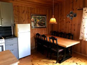 RaulandRauland Hytteutleige的厨房配有木桌和白色冰箱。