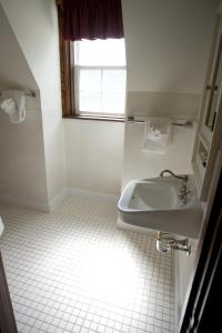 沃特顿公园威尔士王子酒店的白色的浴室设有水槽和窗户。