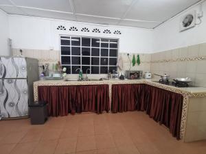Pontian BesarSri Makmur Pontian Homestay的厨房配有长台面和窗帘
