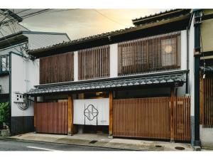 京都Nazuna Kyoto Nijo-jo的一座带木门和围栏的建筑