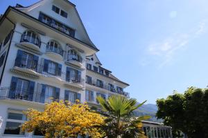 韦吉斯阿姆西美岸中央酒店的一座高大的白色建筑,设有阳台和树木