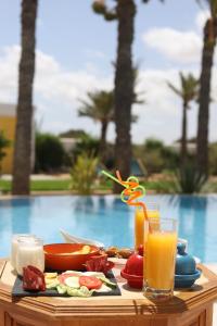 迈来亚Dar El Jerbi的一张桌子,上面放着一盘食物和一杯橙汁