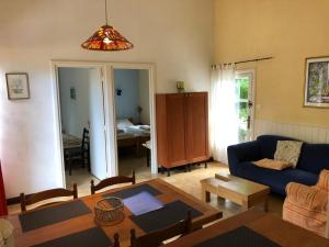 VaraignesL'étang des Mirandes的客厅配有蓝色的沙发和桌子
