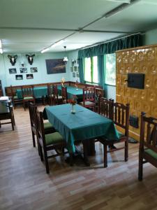 MátraterenyeMátrai Vadászház 2的一间带绿色桌椅的用餐室