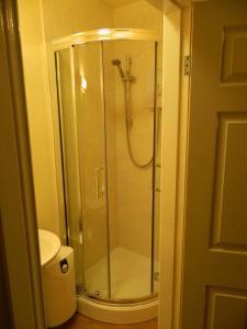 Lanchester皇家橡木宾馆的浴室里设有玻璃门淋浴