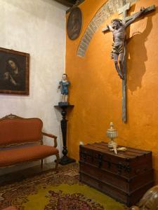 普埃布拉Hotel Boutique Posada XVII的一间设有十字架和椅子的房间