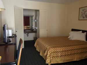佩里斯堡托莱多-佩里斯堡汽车旅馆的酒店客房,配有床和电视