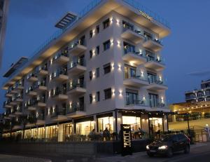 圣金Hotel Bar Restaurant Triumf Shengjin的前面有停车位的建筑