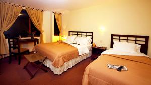 洛哈洛哈圣塞瓦斯蒂安酒店的酒店客房设有两张床、一张桌子和一张书桌。