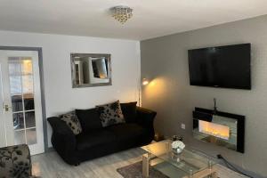阿伯丁Seaview House的客厅配有沙发和墙上的电视