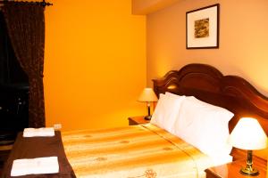 利马Solis Dies Hotel的酒店客房的床铺拥有黄色的墙壁