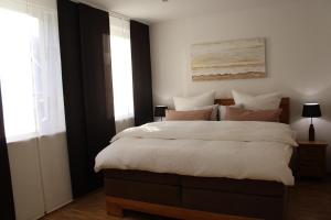 柯尼希施泰因易北Luxuriöse Stadtwohnungen in Königstein的卧室配有一张带白色粉色枕头的大床