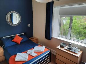 伯恩茅斯斯图尔特山酒店 的一间卧室设有蓝色的床和窗户。