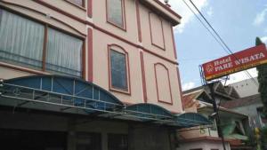 ParepareHotel Parewisata的一座粉红色的建筑,其一侧设有阳台