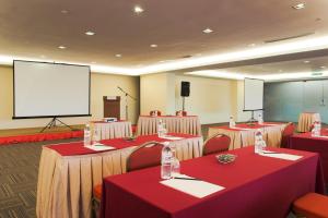 塞贝维Hotel Primera Suite - formally known as Tan Yaa Hotel Cyberjaya的一间会议室,配有桌椅和屏幕