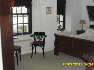 阿里塞格The Old Library & Lodge的一间卧室配有一张床、一把椅子和窗户。