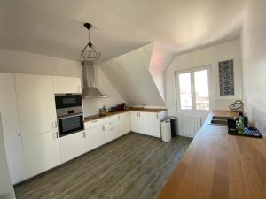 基伯龙Appartement Quiberon的一间设有白色橱柜和窗户的大厨房
