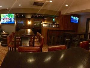 格兰奇茅斯Oxgang Kitchen Bar & Rooms的酒吧配有桌椅和电视