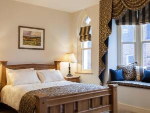 纽敦Parkers House Bed & Breakfast的一间卧室设有一张大床和两个窗户。