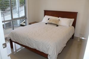 陶波Luxury Retreat with Swim Spa的卧室内的一张带木制床头板的床