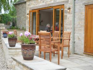 切尔滕纳姆The Plough Inn的庭院配有椅子和鲜花桌子
