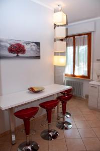福利尼奥A casa di Debby alloggio comodo e accogliente的厨房配有白色柜台和红色吧台凳