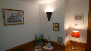 MaßweilerPension Landhaus Fischer的配有一张桌子、一盏灯和一瓶水的房间