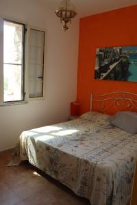 帕图Specchiulla的一间卧室配有一张橙色墙壁的床