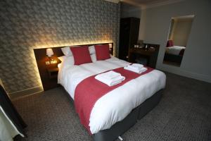 罗斯伯里The Queens Head Hotel的酒店客房带一张大床,带毛巾