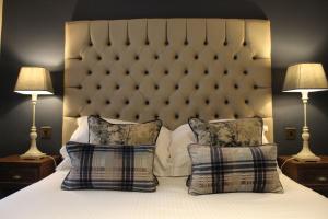 柯比朗斯代尔Red Dragon Inn的一间卧室配有一张带两个枕头和两个灯的床。