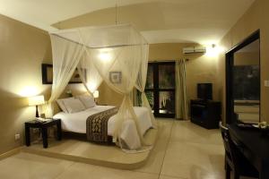 塞米亚克杜顺酒店的一间卧室配有一张带天蓬的床