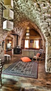 ‘Eilabūn19th Century Magical House in Galilee的带沙发和石墙的客厅