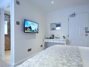 Thorpe le SokenThe Rose and Crown的卧室配有一张床,墙上配有电视。