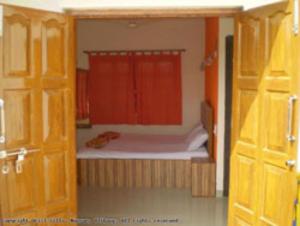 阿利鲍格Drisl Villa 3BHK的一间小卧室,配有一张带红色窗帘的床