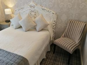 法尔茅斯Rosemullion Hotel的卧室配有白色的床和椅子