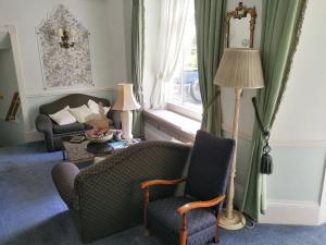 法尔茅斯Rosemullion Hotel的客厅配有两把椅子、一张沙发和一个窗口