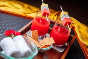 会安RiverTown Hoi An Resort & Spa的装有两杯红果汁和饼干的托盘