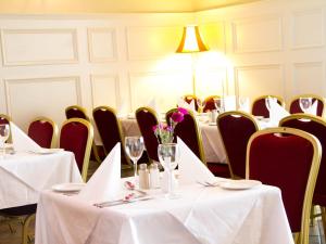 邓甘嫩The Ryandale Inn的用餐室配有桌椅和白色桌布