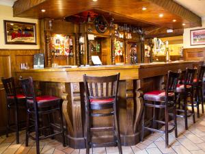 邓甘嫩The Ryandale Inn的餐厅内带木制酒吧凳的酒吧