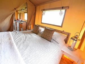DennyCarr's Hill Luxury Safari Tents的卧室配有白色的床和窗户