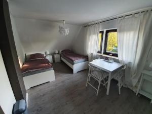 诺德施泰特@ home Zimmervermietung的客房设有两张床、一张桌子和一扇窗户。