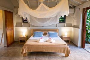 勒穆莱香巴拉山林小屋的一间卧室配有一张床,上面有两条毛巾