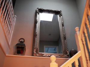 纽基Skyline Guesthouse的楼梯旁墙上的镜子